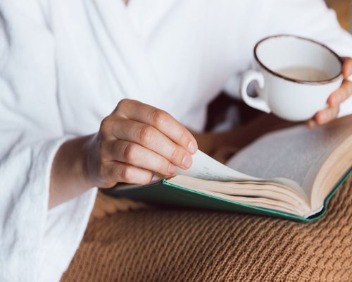 Person relaxing peacefully with a book on a quiet weekend