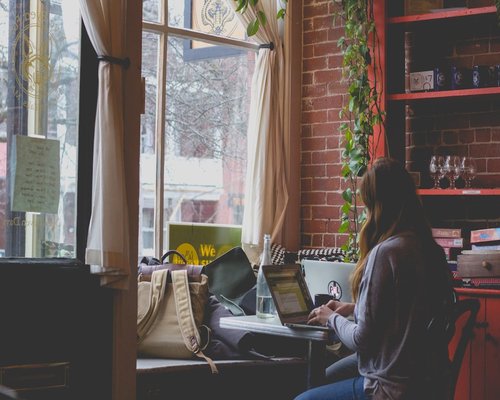 Woman maintaining comfortable posture while working on a laptop at a cafe